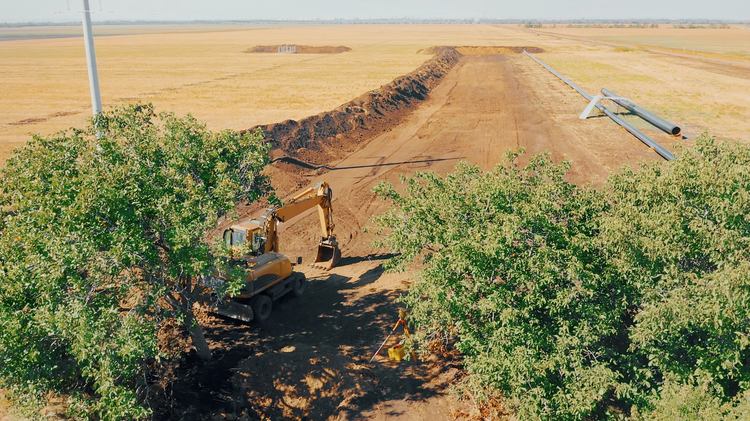 Excavator digging trench for utility line installation